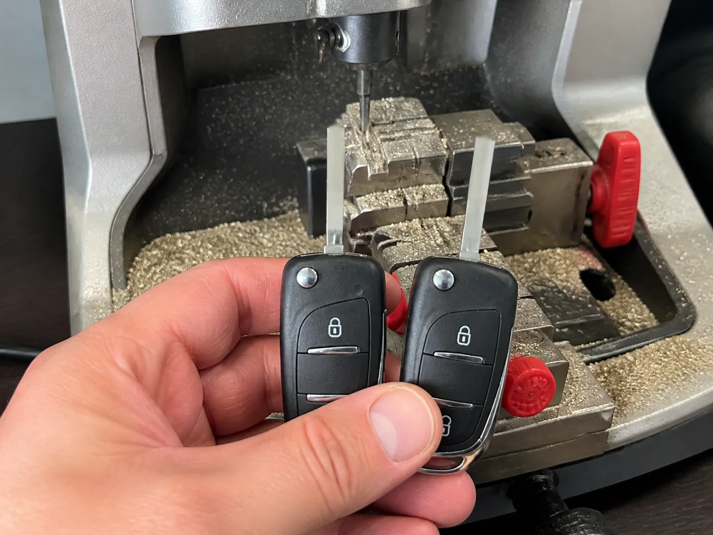 Twee autosleutels bij de sleutelsnijmachine van MO Autosleutels